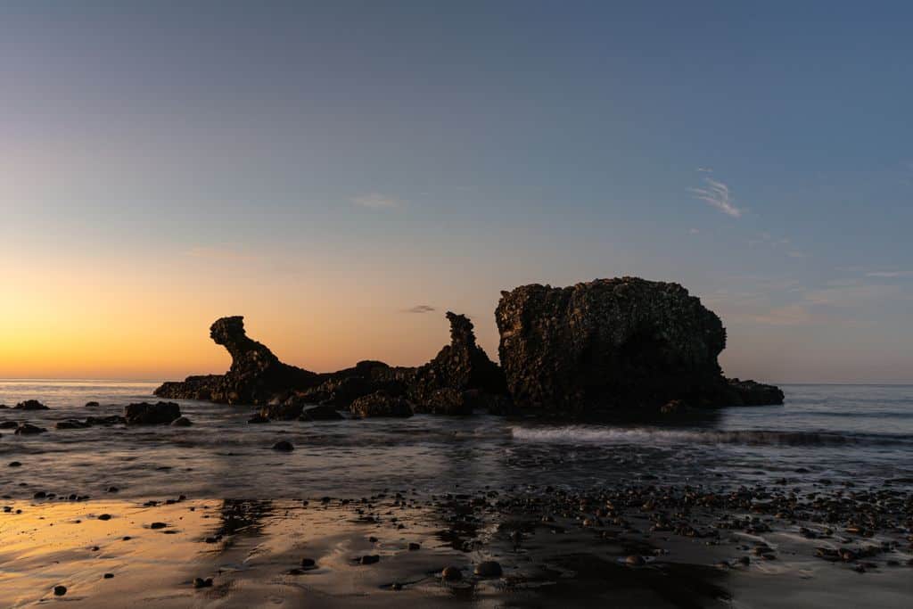 Breathtaking sunset view at El Tunco beach with iconic rock formations and serene waves.